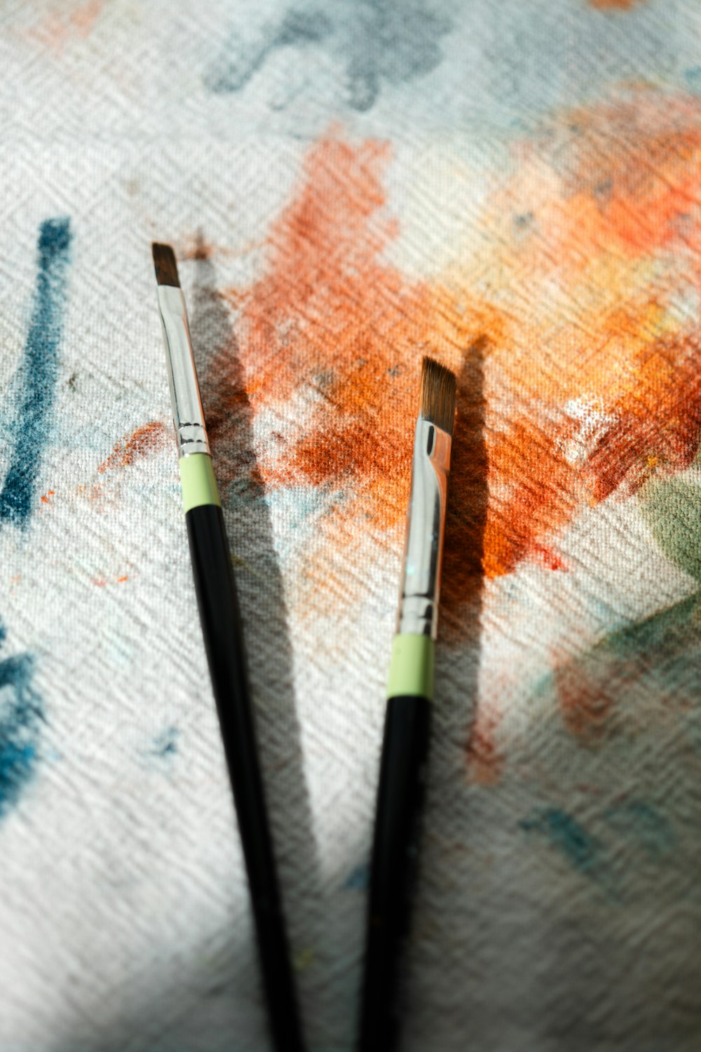 two paint brushes sitting on top of a piece of paper