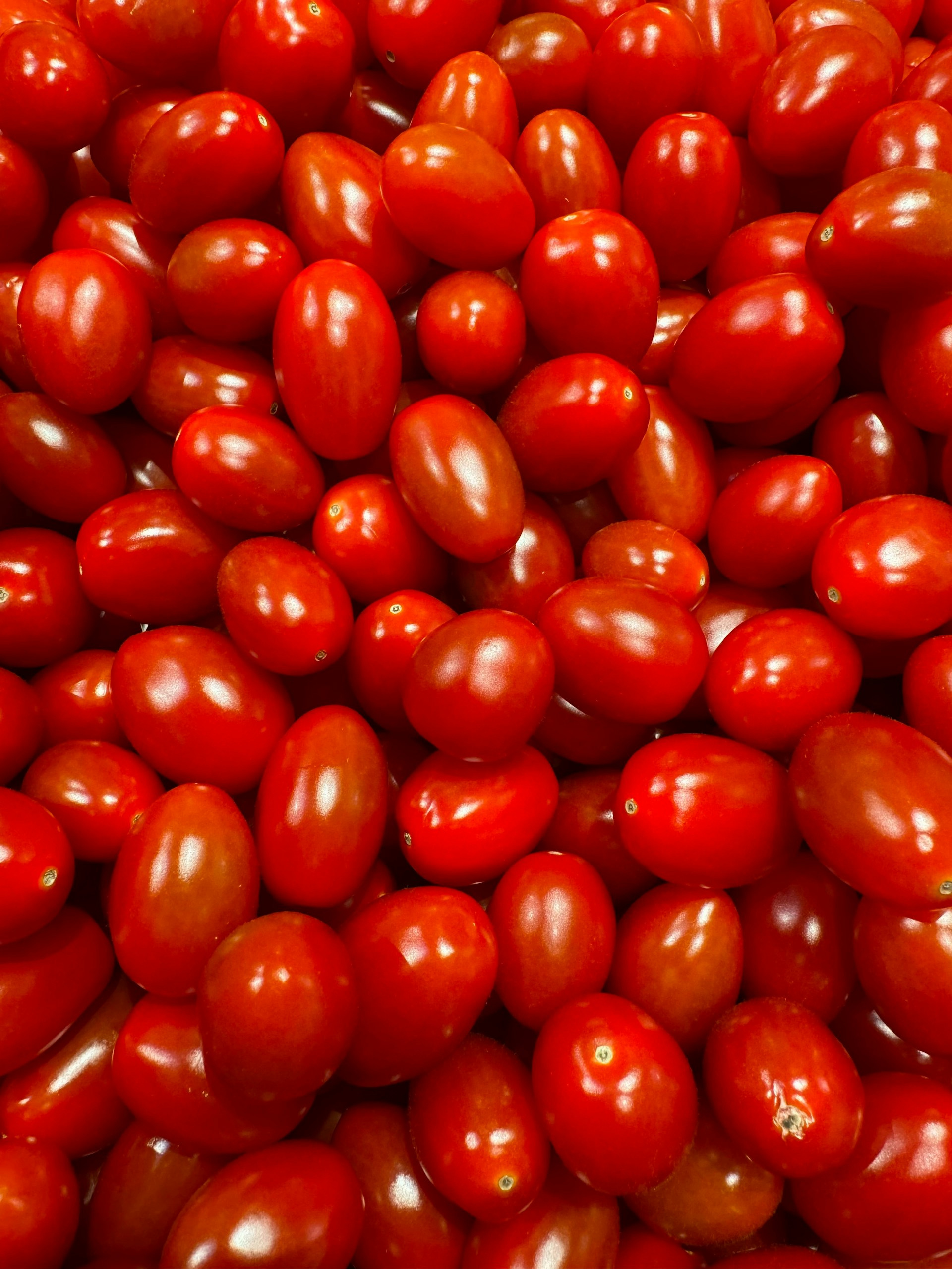 a pile of red tomatoes sitting on top of each other