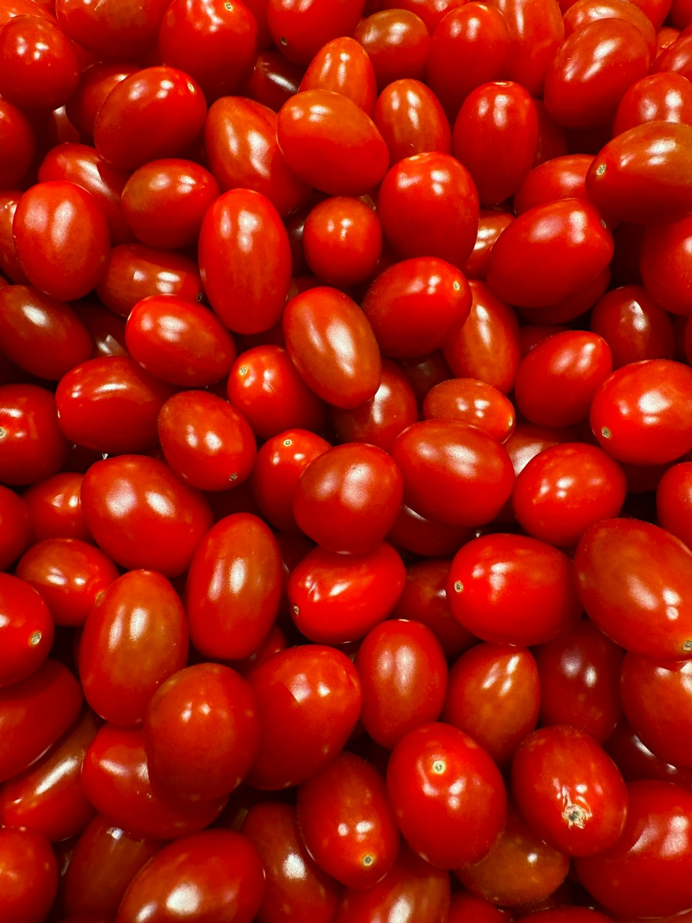 a pile of red tomatoes sitting on top of each other