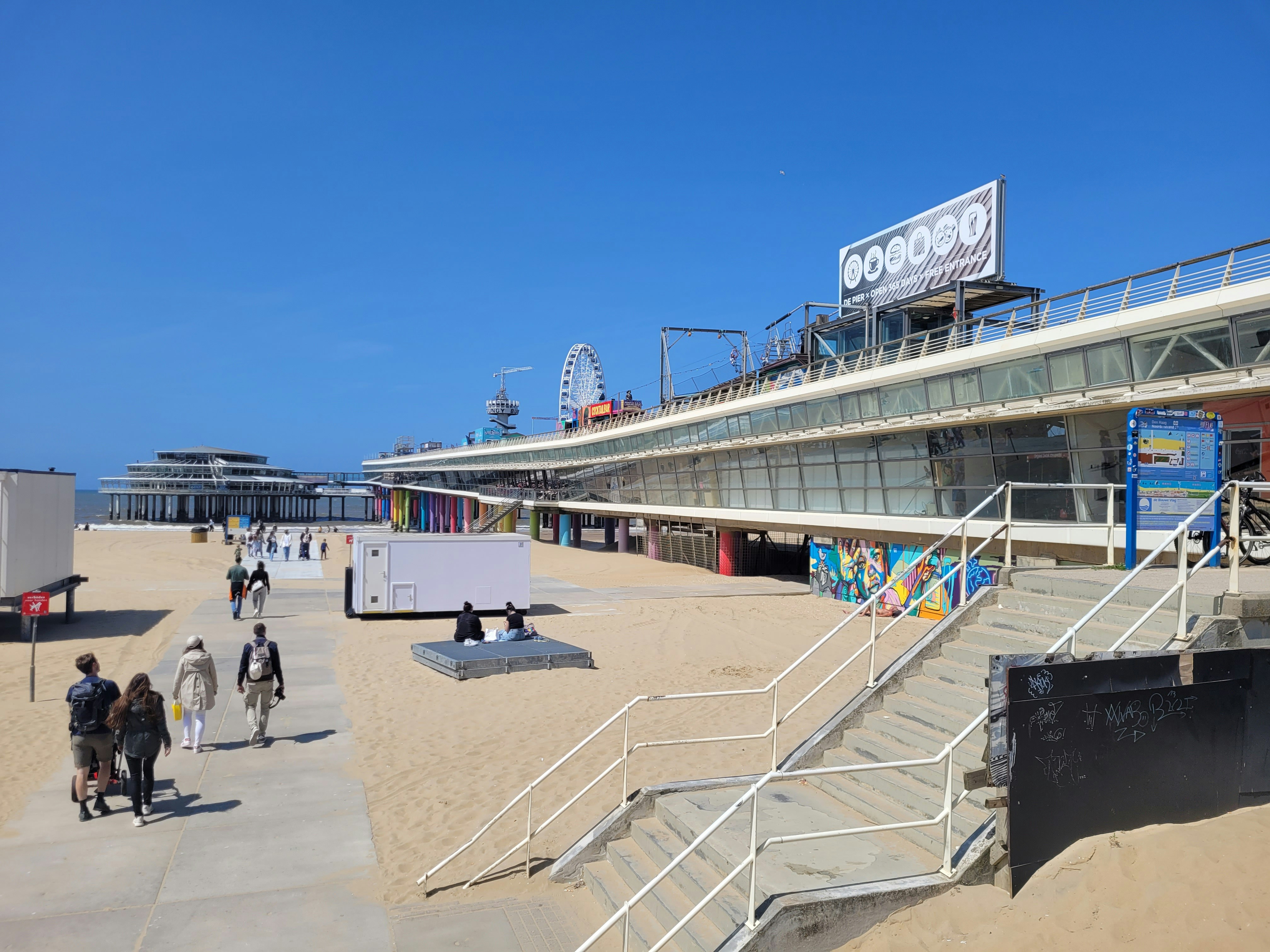 a group of people walking around a sandy beach