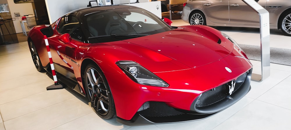 a red sports car is on display in a showroom