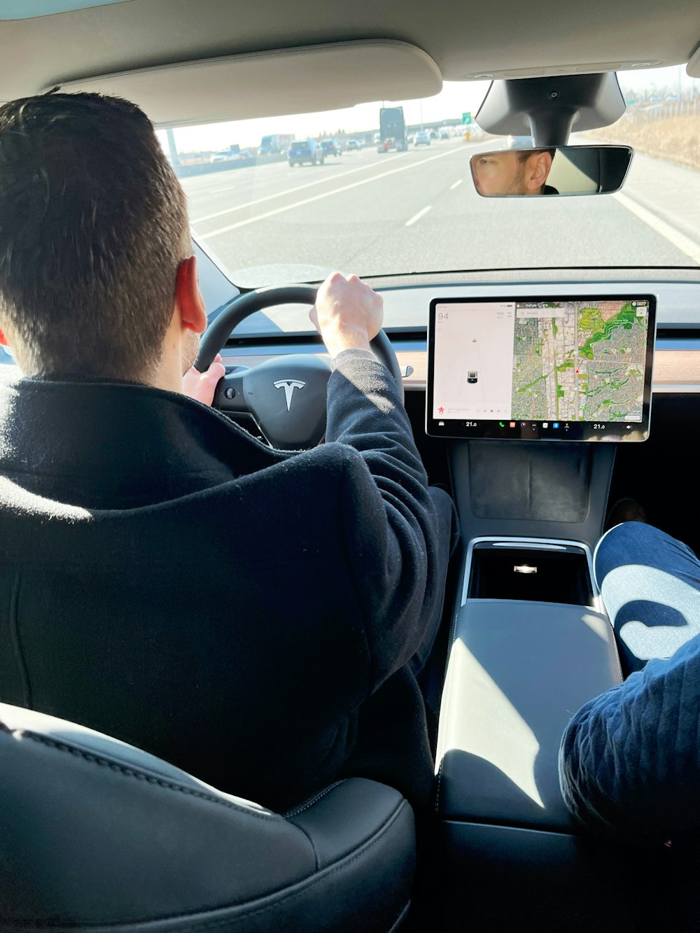 a man driving a car while holding a tablet