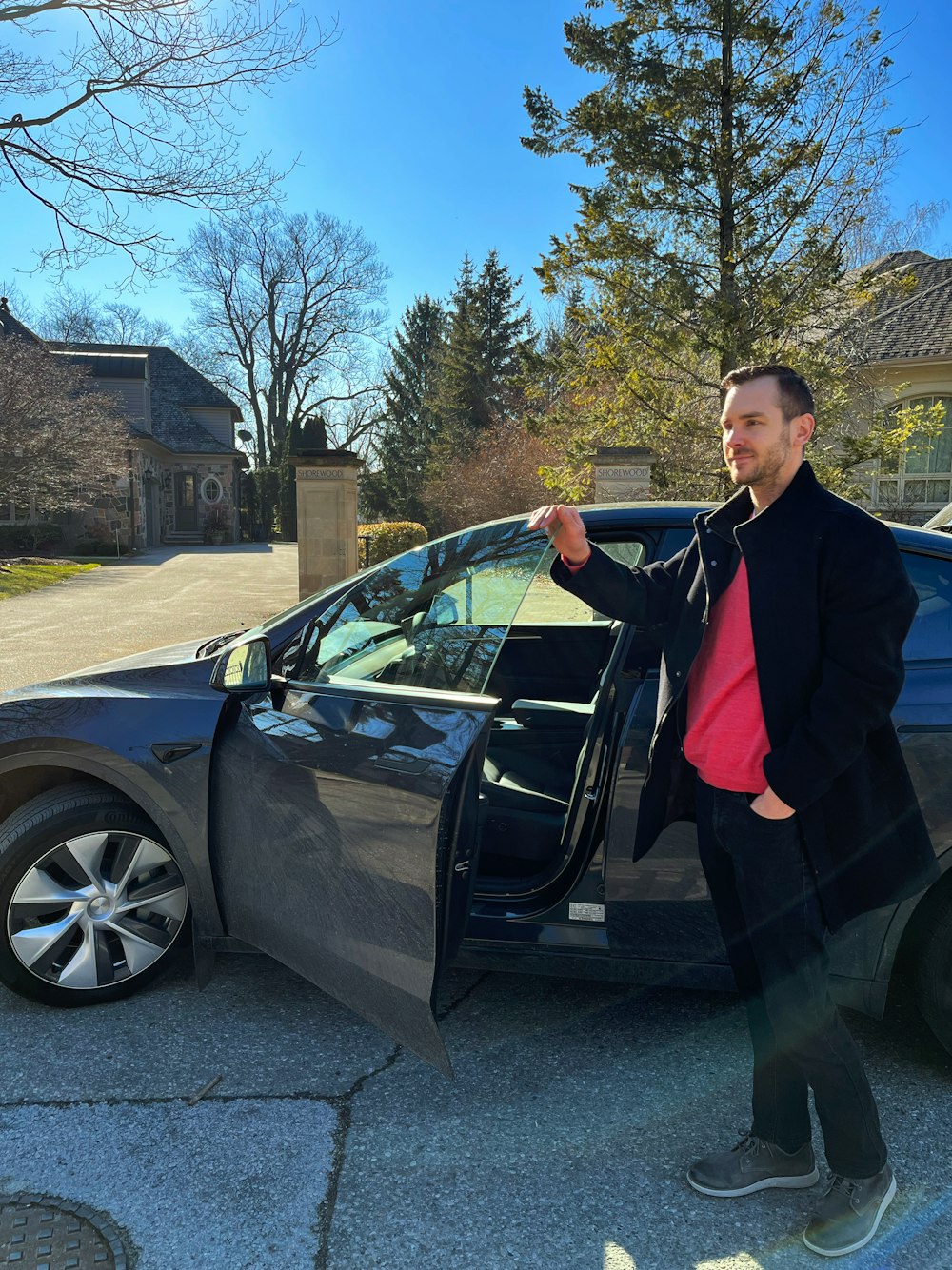 a man standing next to a car with its door open