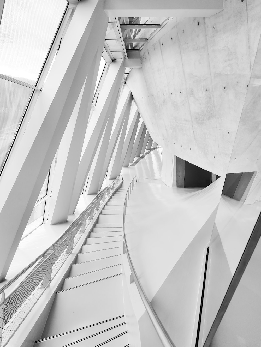 a black and white photo of a curved staircase