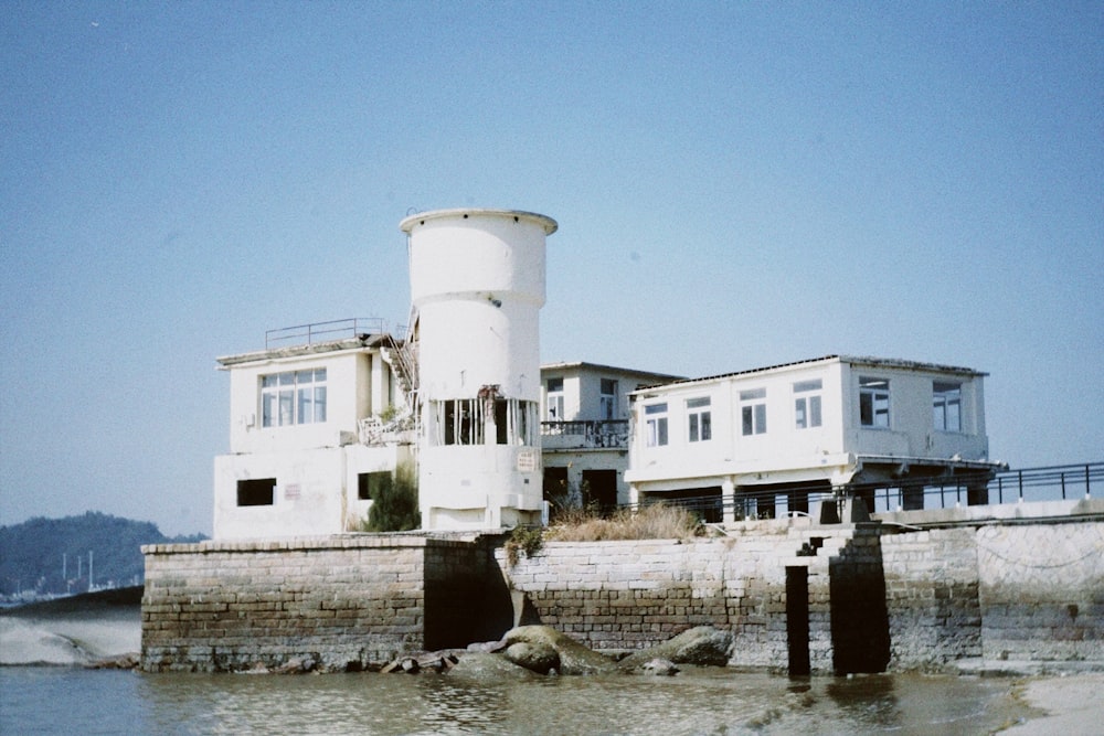 a large white building sitting next to a body of water