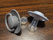a pair of pacifiers sitting on top of a wooden table