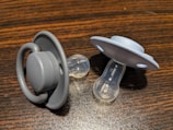a pair of pacifiers sitting on top of a wooden table