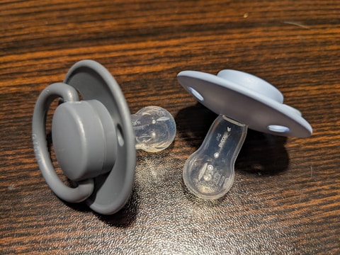 a pair of pacifiers sitting on top of a wooden table