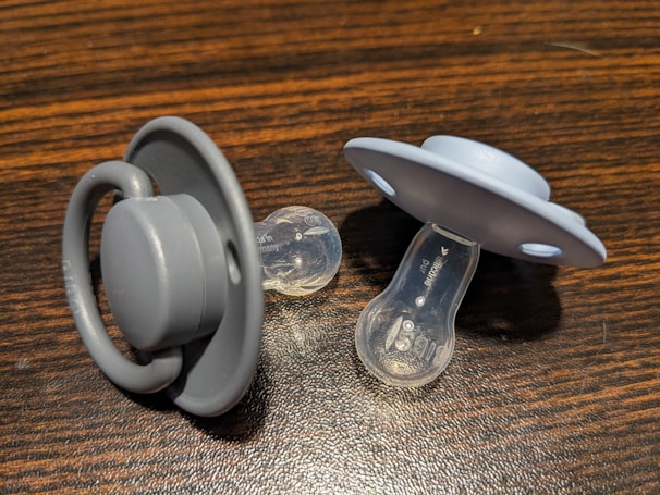 a pair of pacifiers sitting on top of a wooden table