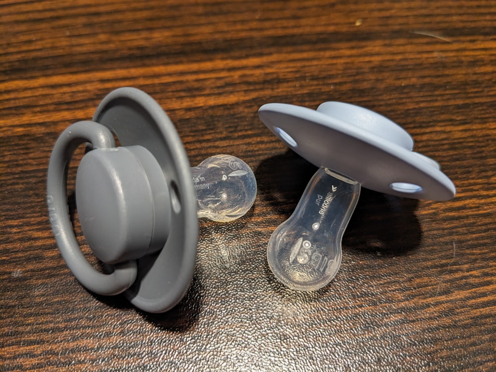 a pair of pacifiers sitting on top of a wooden table