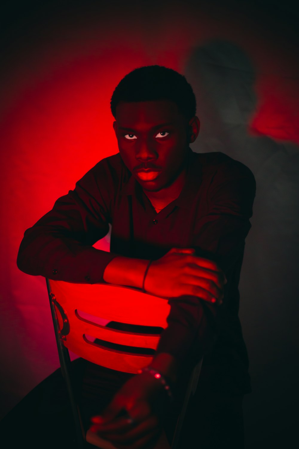 a man sitting in a chair with a red light on his face