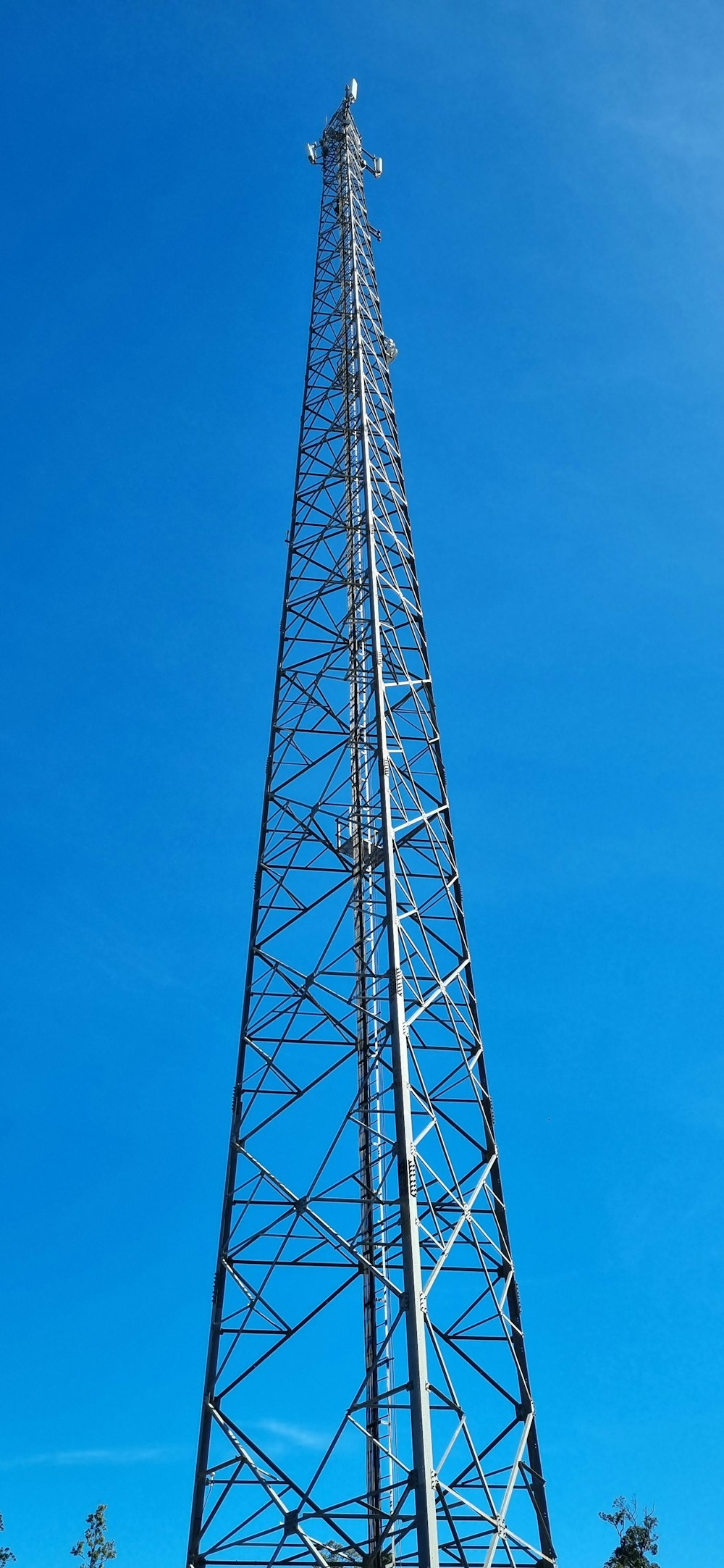 a tall metal tower sitting on top of a lush green field