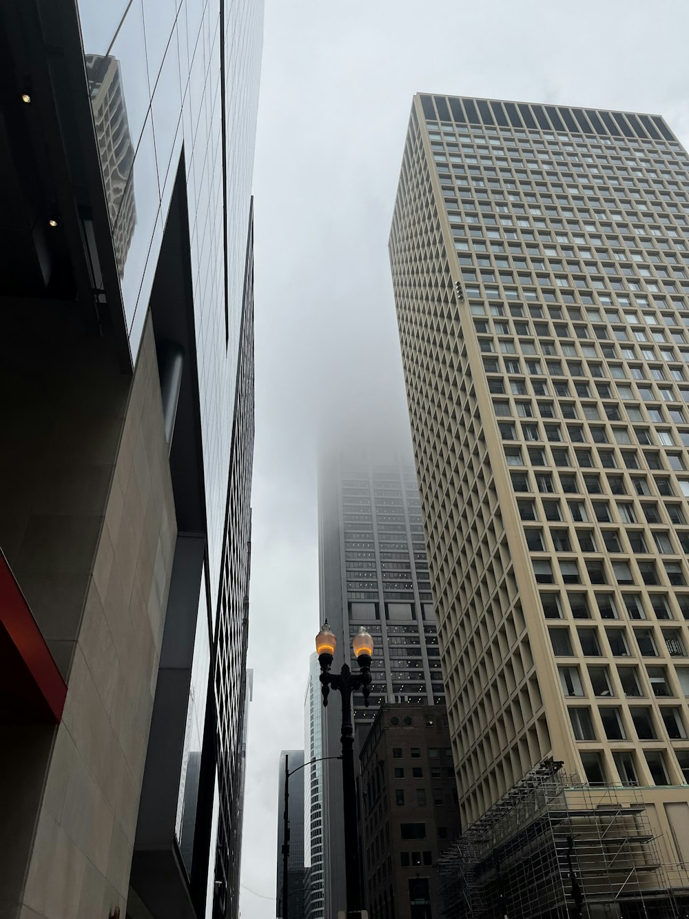 a city street with tall buildings on a cloudy day