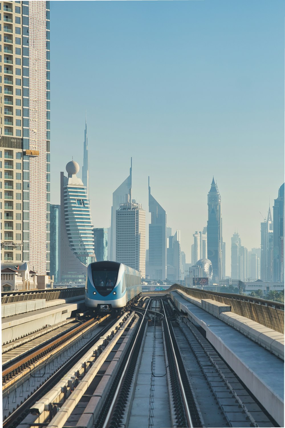 a train traveling through a city next to tall buildings