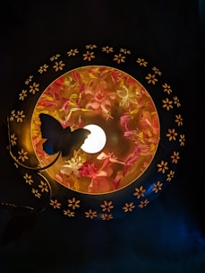 a lamp with a butterfly on it in a dark room