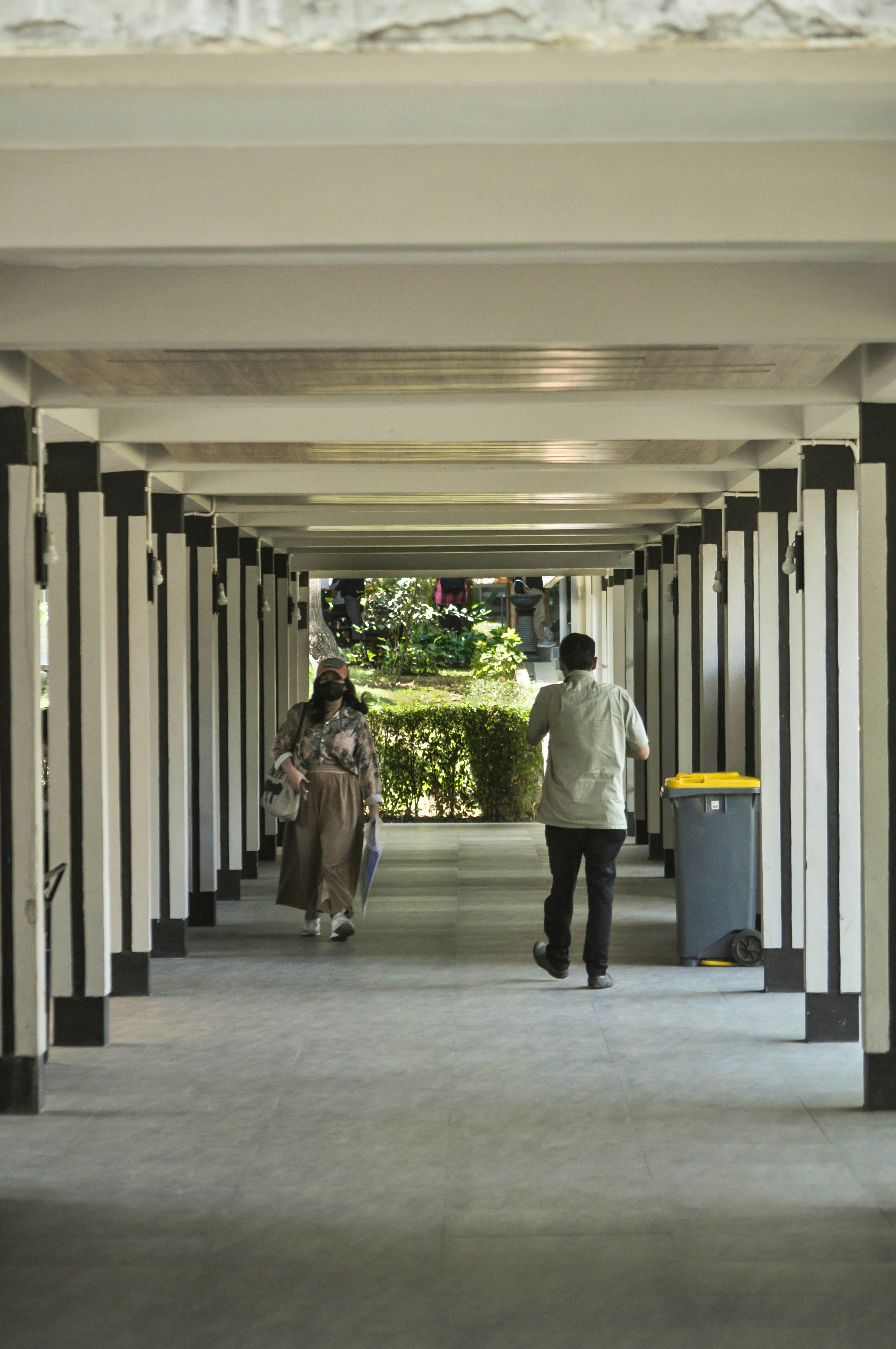 Beberapa orang berjalan menyusuri lorong panjang