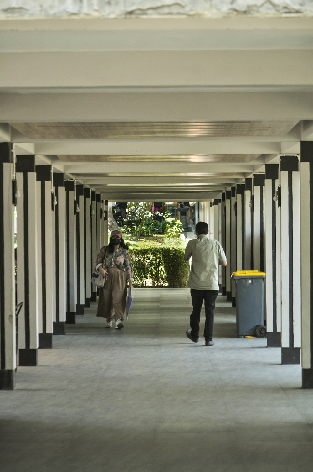 a couple of people walking down a long hallway