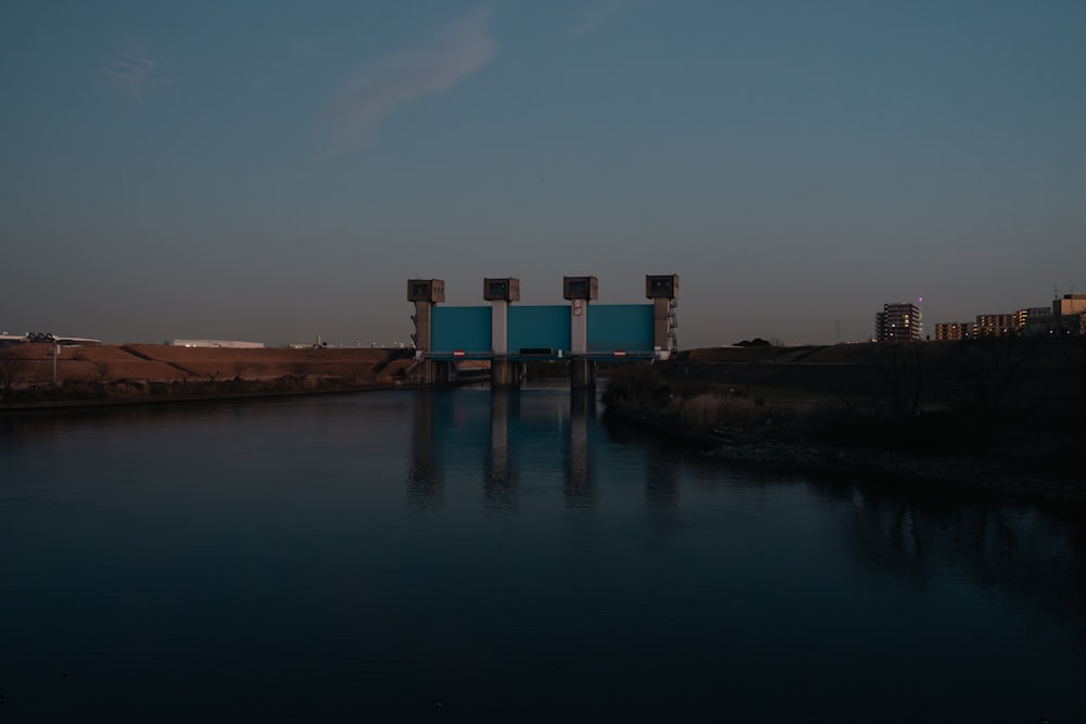 a body of water with a bridge in the background