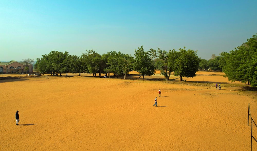 a group of people standing on top of a dirt field