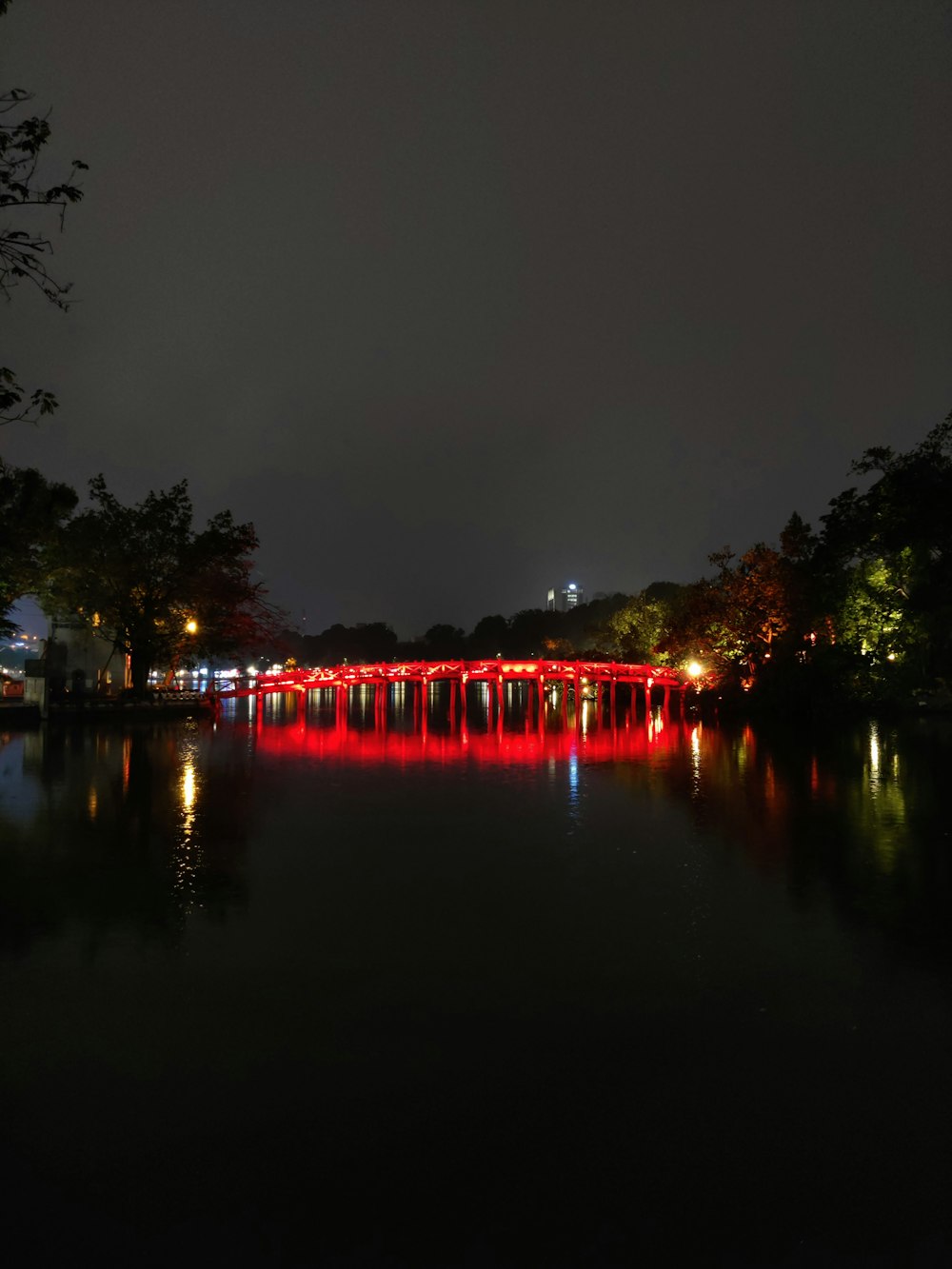 a red bridge lit up at night over a body of water