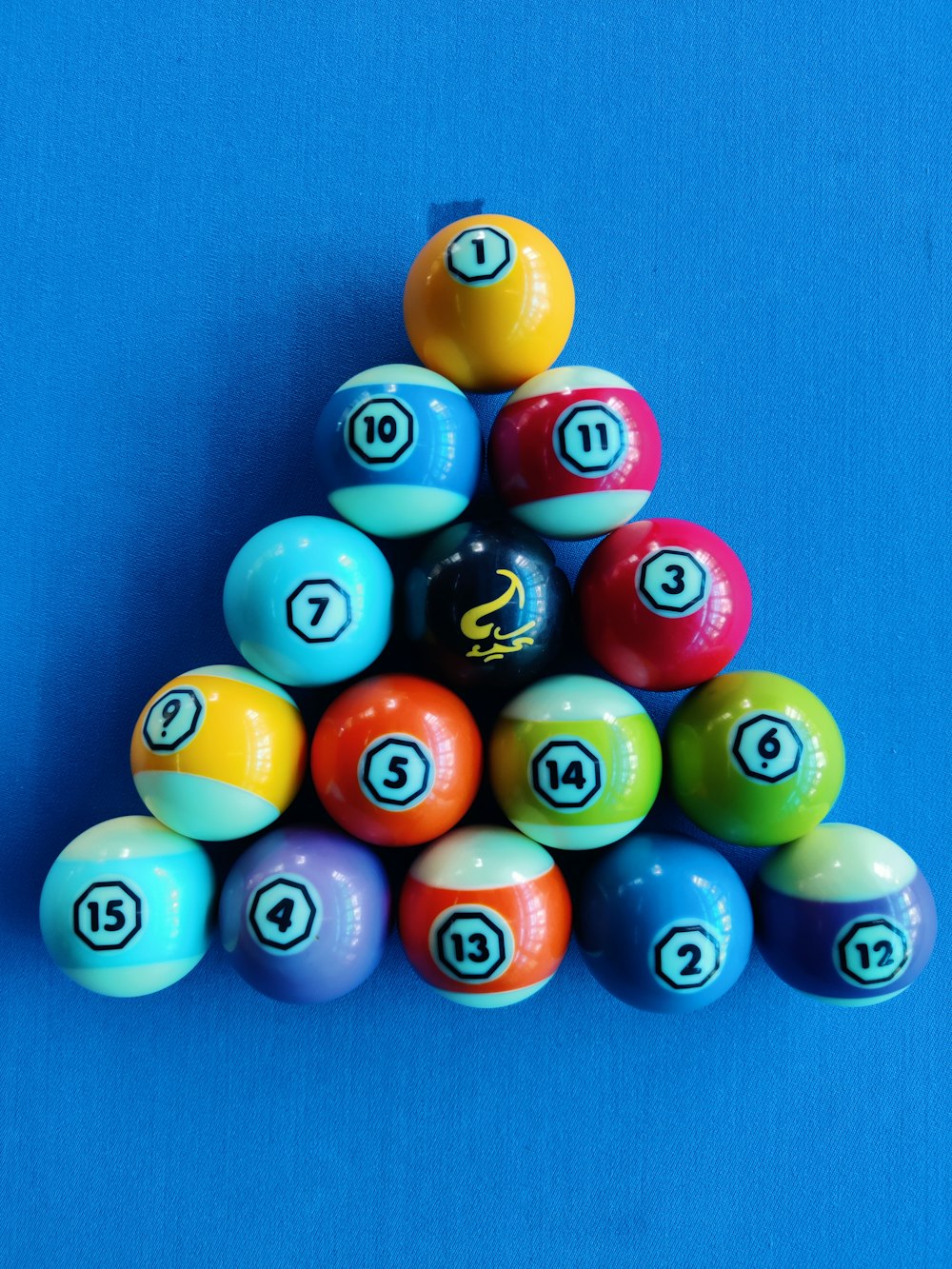 a pyramid of pool balls on a blue background