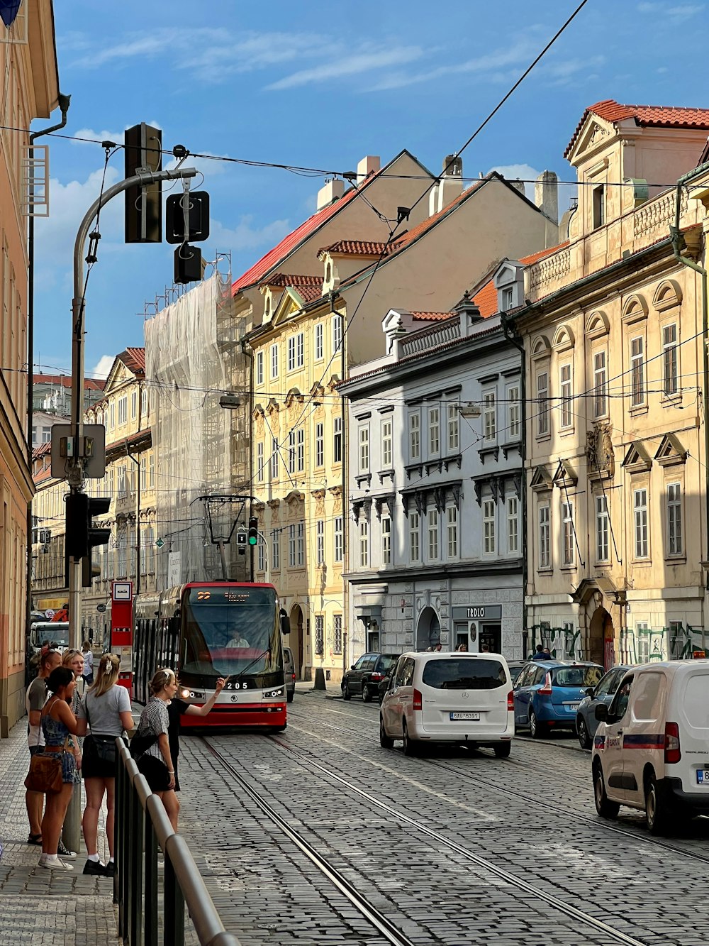 a group of people standing on a sidewalk next to a street