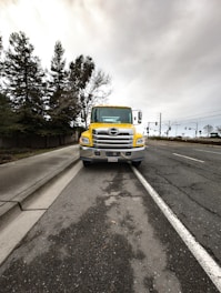 a yellow truck is parked on the side of the road