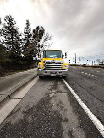 a yellow truck is parked on the side of the road