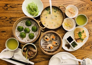 a wooden table topped with bowls of food