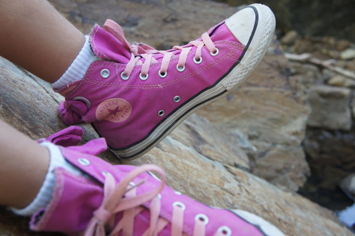 Close-up of a child's pink canvas sneakers during outdoor play