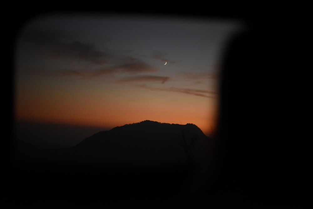 a view of a mountain at sunset from a plane window