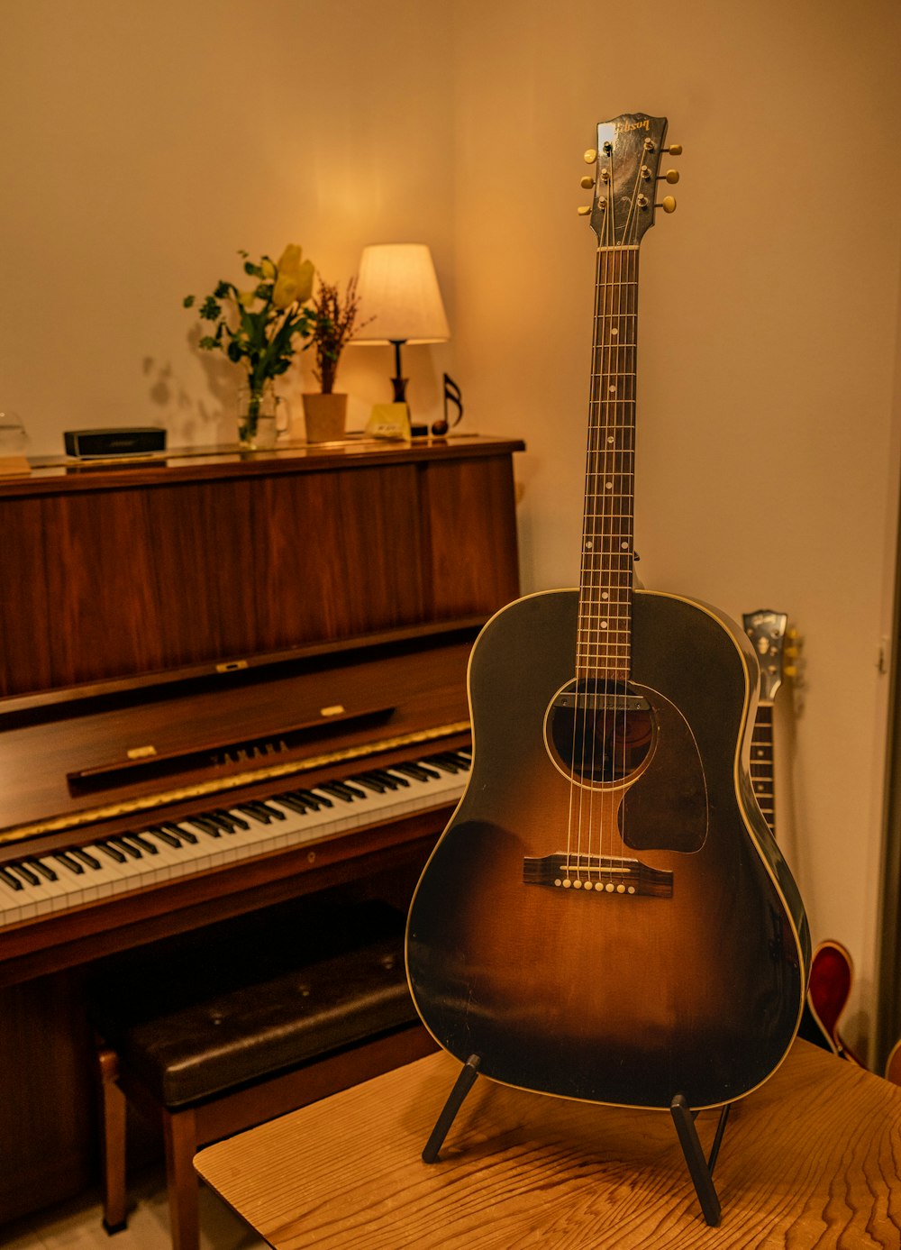 a guitar sitting on top of a table next to a piano