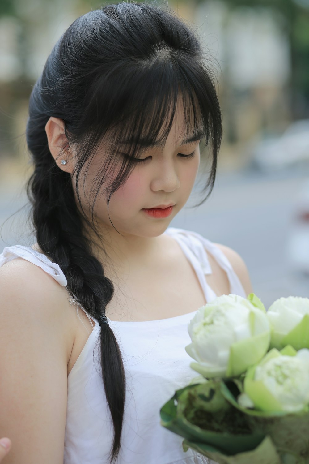 a woman holding a bouquet of white flowers