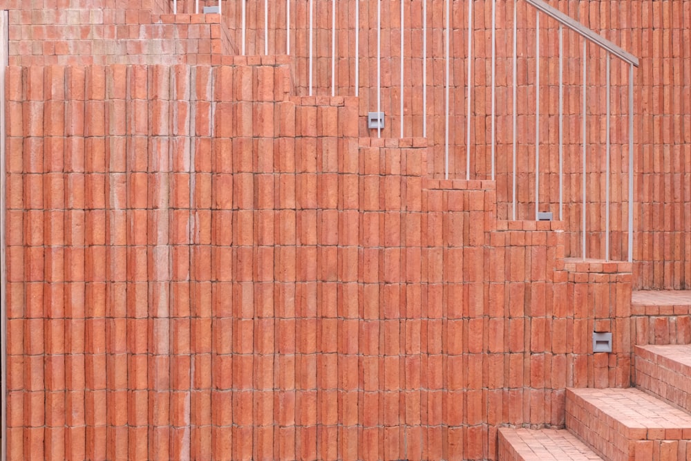 uma parede de tijolos vermelhos com degraus que levam até ela