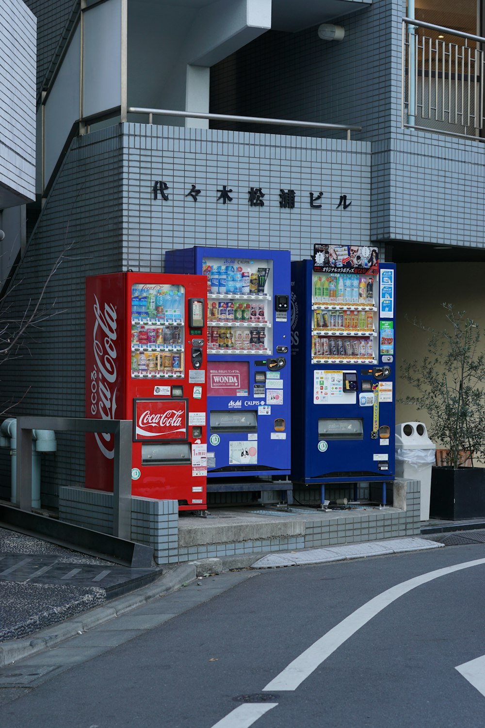 a row of vending machines on the side of a street