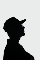 a silhouette of a man wearing a hat