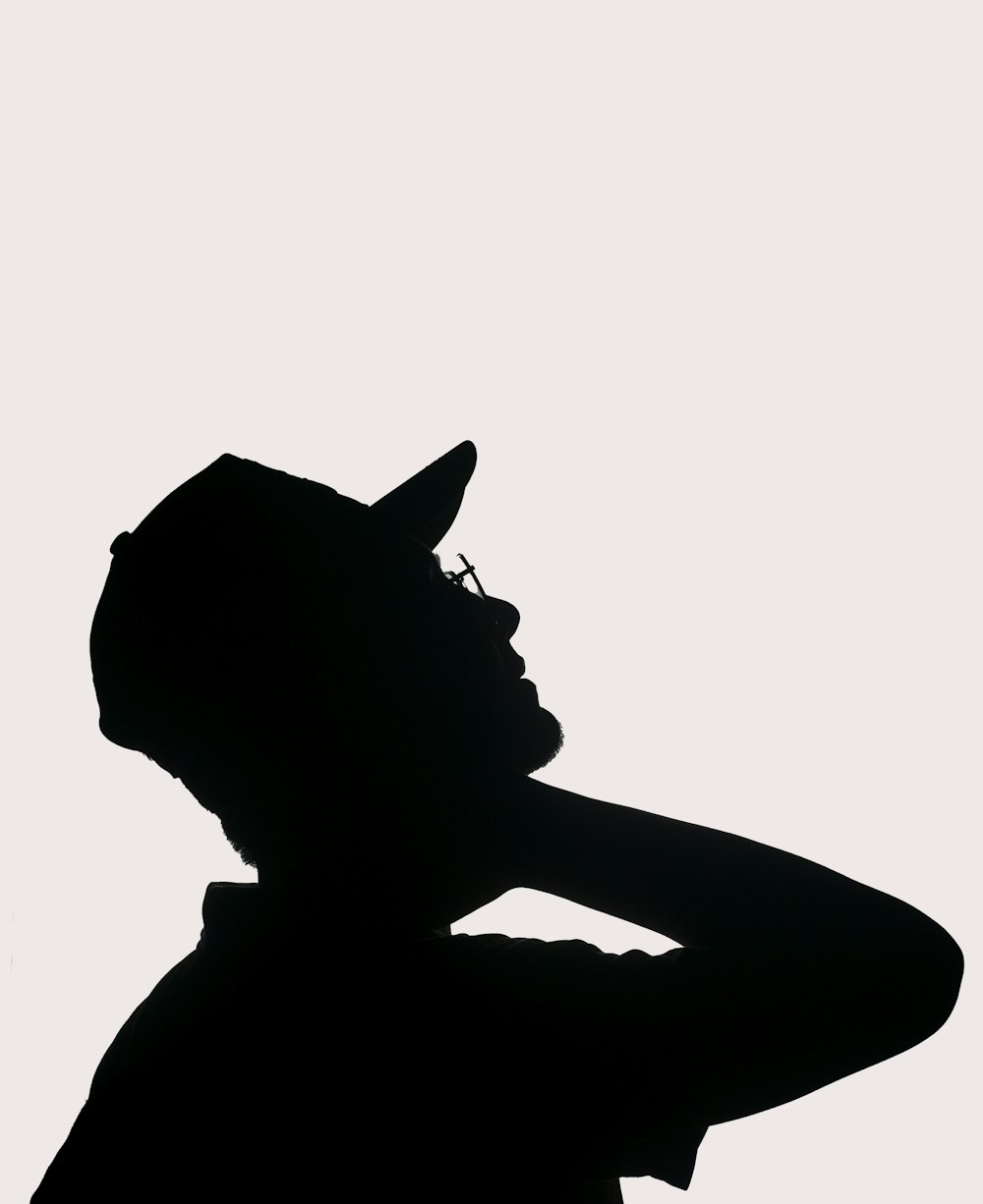 a silhouette of a person wearing a hat