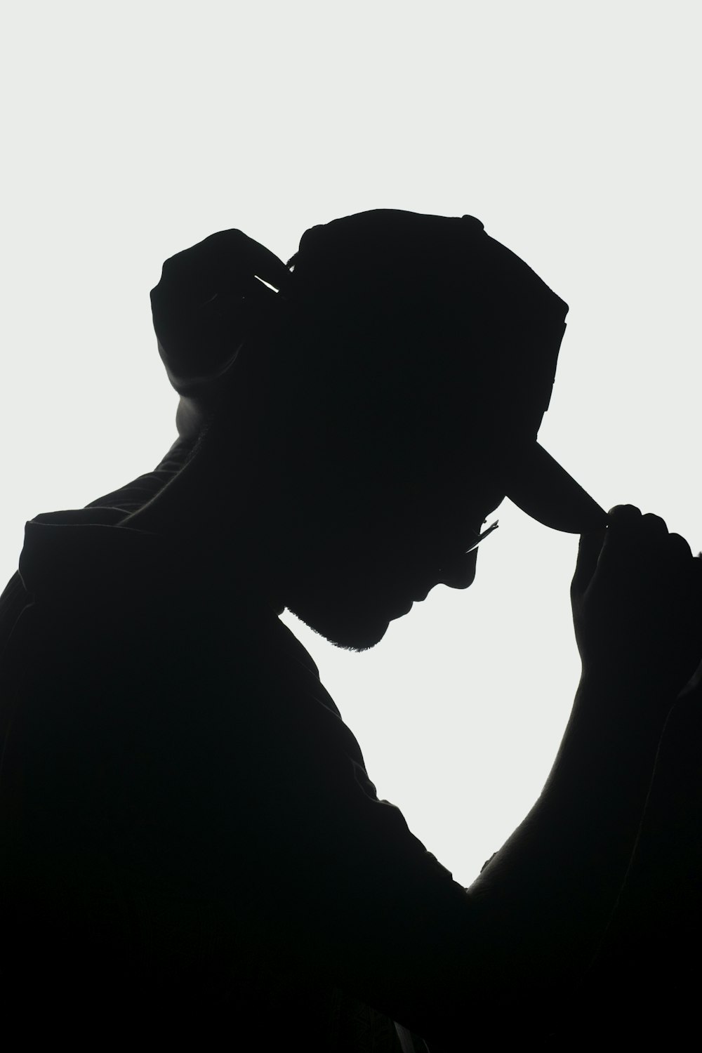 a silhouette of a person holding a cell phone to their ear