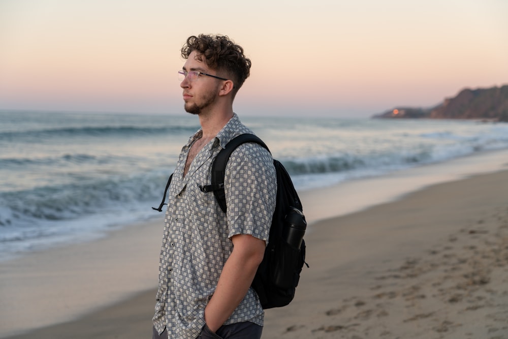 a man with a backpack standing on a beach