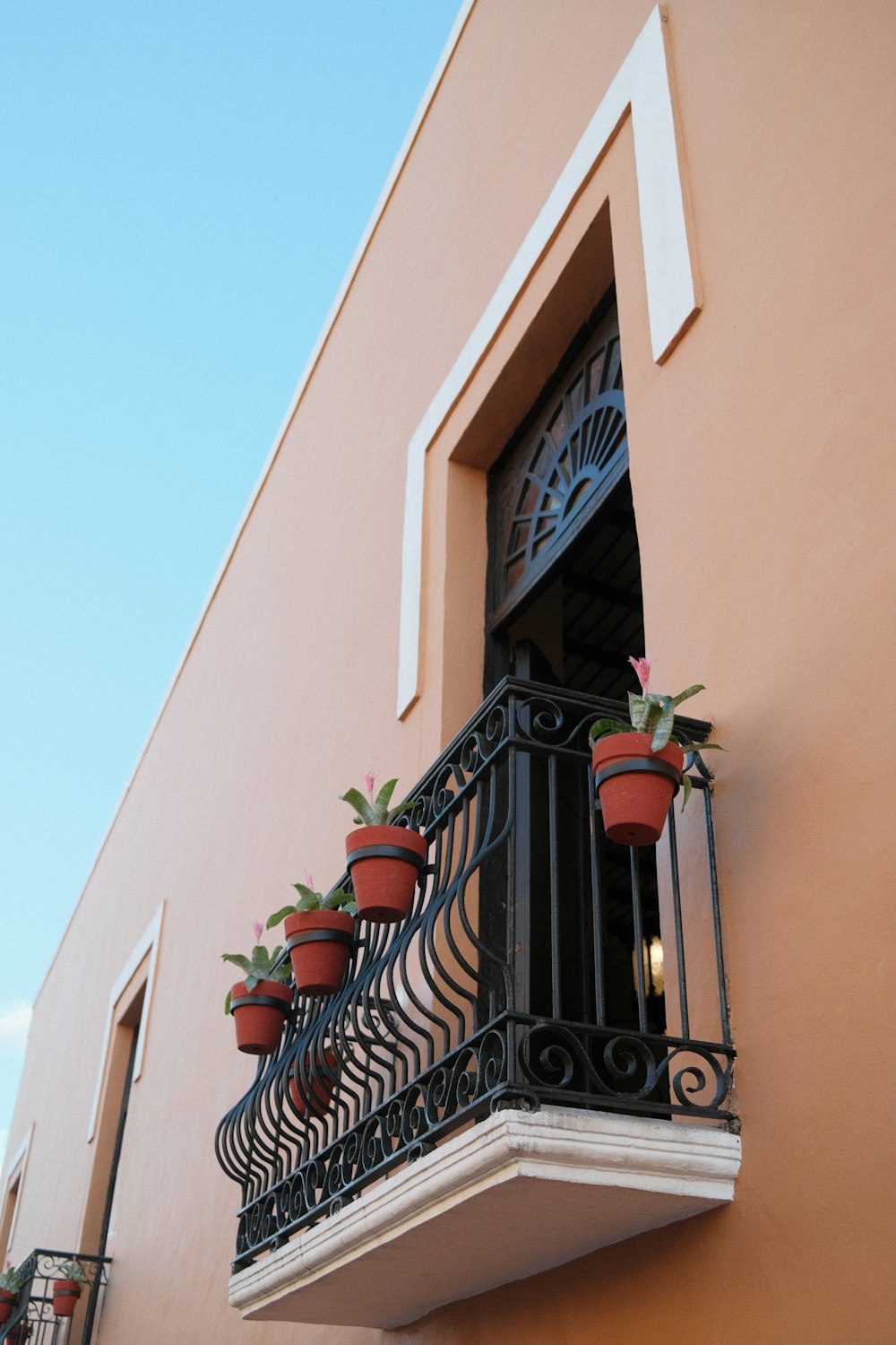 a balcony with potted plants on the balconies
