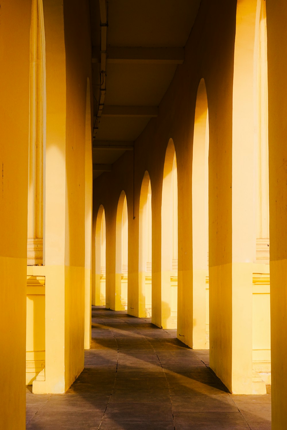 a row of yellow pillars on a sidewalk
