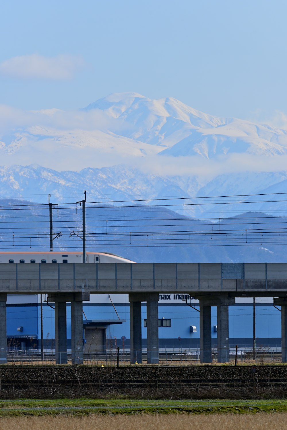 a train traveling over a bridge with mountains in the background