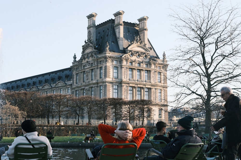 a group of people sitting in lawn chairs in front of a building