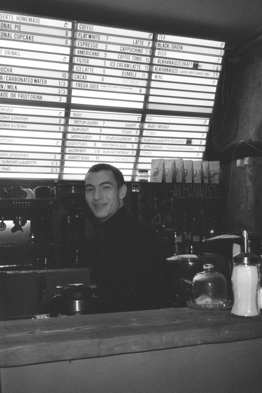 a man standing behind a counter in a restaurant