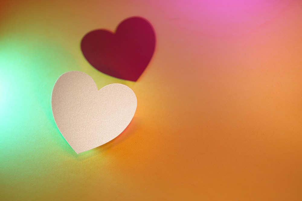 two paper hearts sitting on top of a table