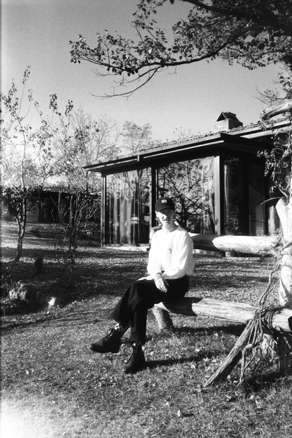 a black and white photo of a man sitting on a bench