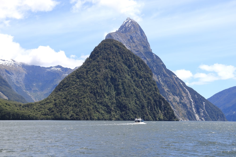 um barco em um corpo de água com montanhas ao fundo