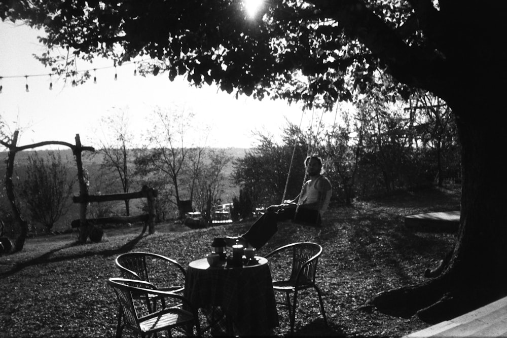 a person sitting at a table under a tree