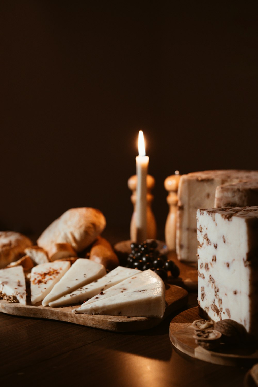 a table topped with cakes and pastries next to a candle