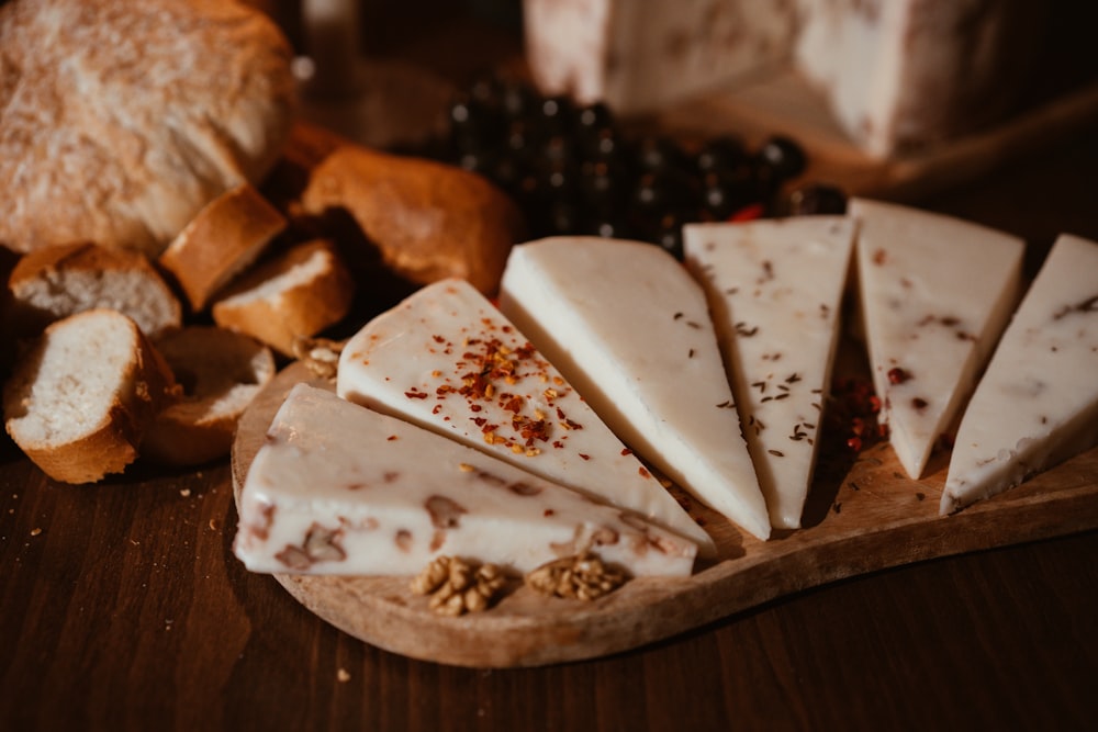 a wooden cutting board topped with slices of cheese